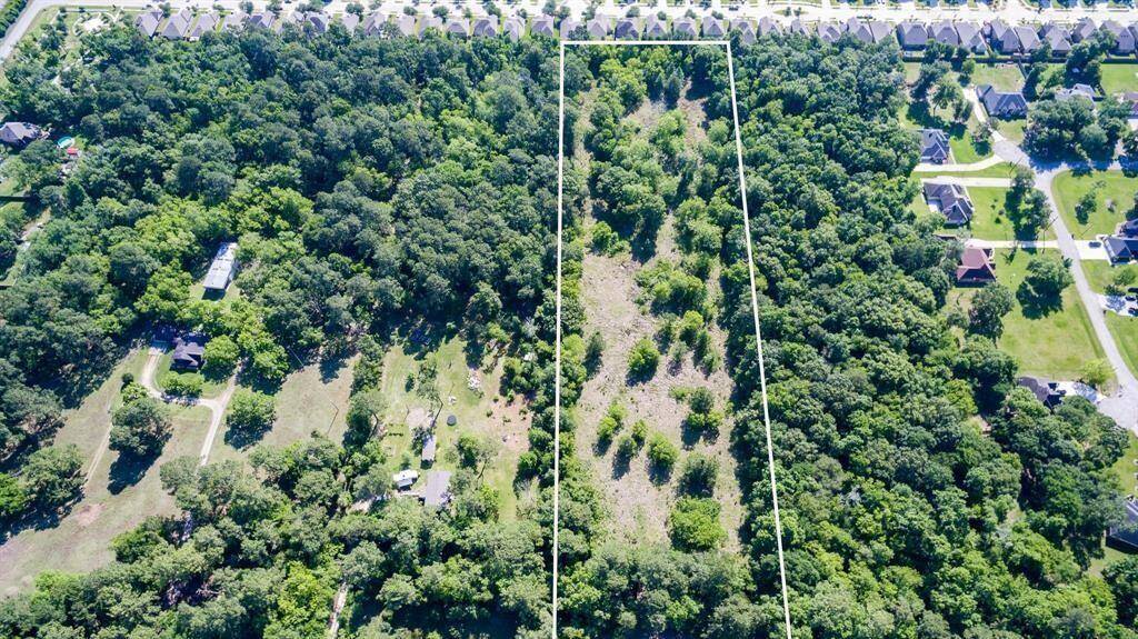 This aerial photo showcases a large, undeveloped land parcels surrounded by established neighborhoods, offering a blend of open space and wooded areas, ideal for potential development or a private estate within a suburban setting.
