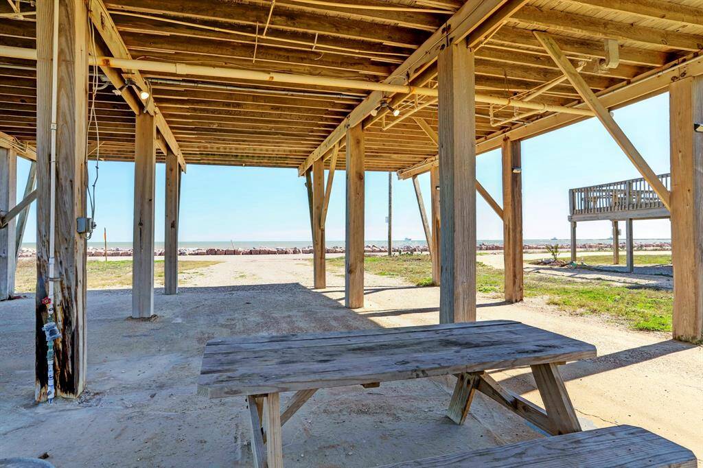 Elevated beachside structure with a wooden deck area, offering scenic ocean views. Ideal for outdoor relaxation and enjoying coastal breezes.