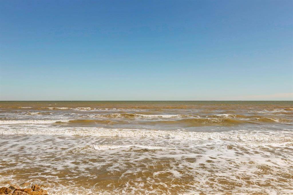 Expansive ocean view with gentle waves under a clear blue sky, perfect for a serene coastal living experience.