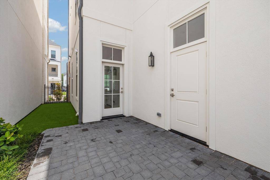 Private courtyard features patio and artificial turf, accessible from glass door in house, side door to garage and back gate from curb.