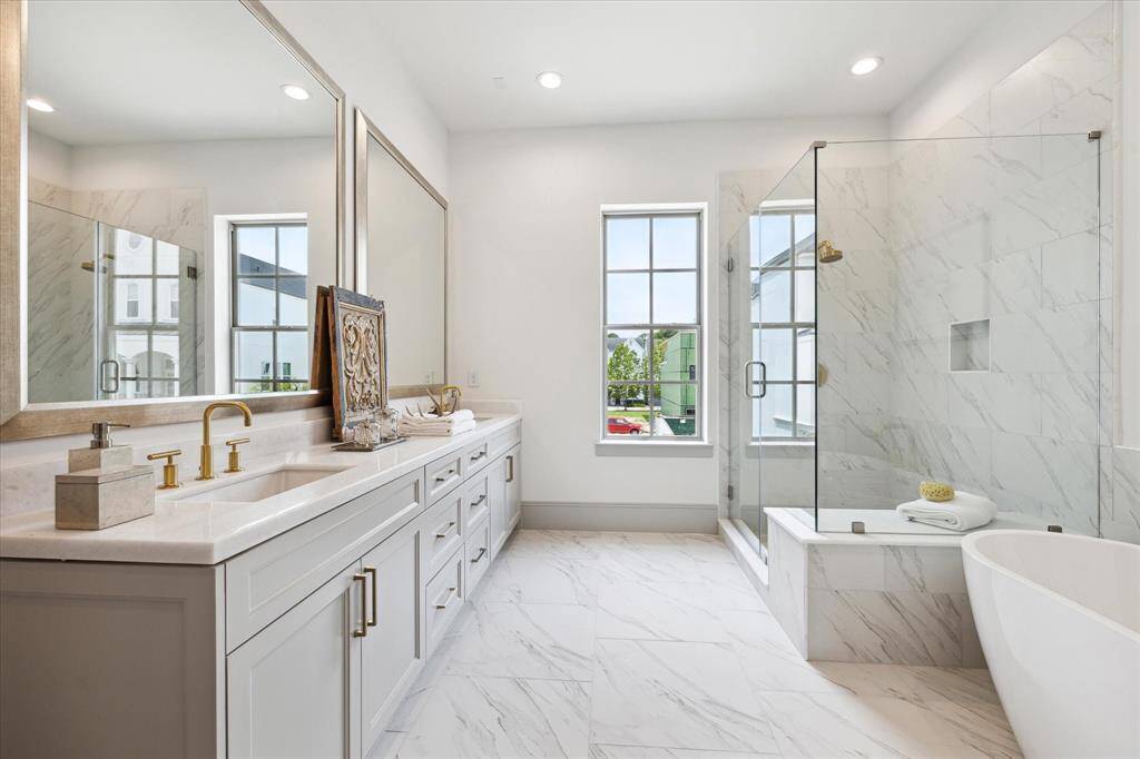Opal White Polished Marble Countertops with double sinks, soaking tub, glass walk-in shower and Carrara Matte Marble floors.