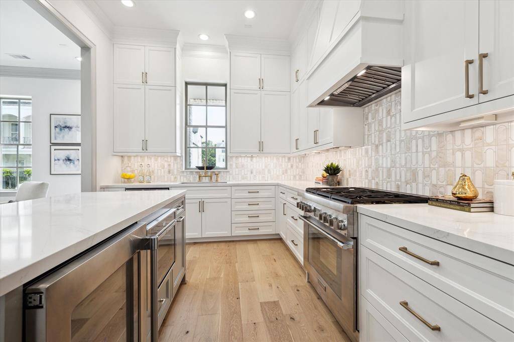 Thermador gas range, plentiful cabinetry with uppers, island with wine refrigerator and Thermador microwave.