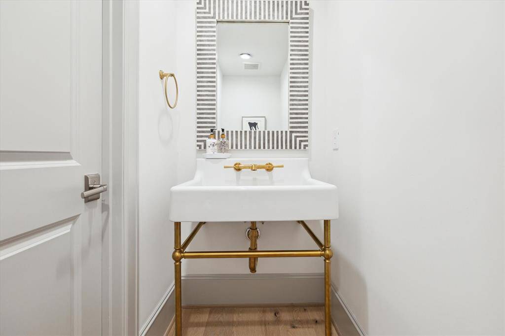 Powder Bath features console sink with brass details.