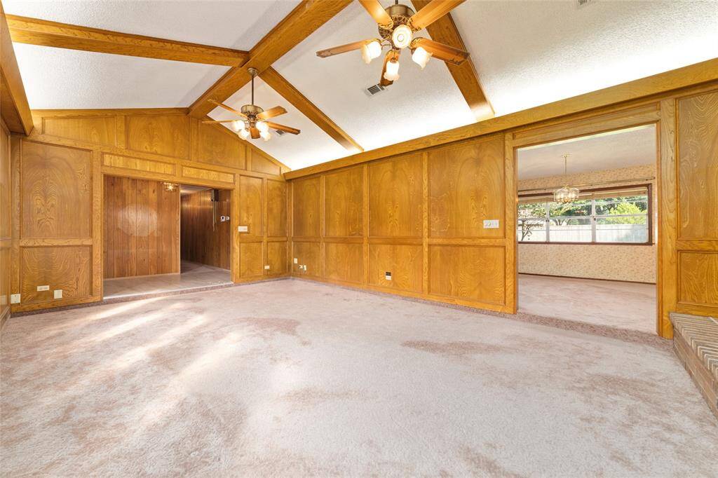 Huge family room with vaulted ceilings, tray lighting, and gorgeous beams.