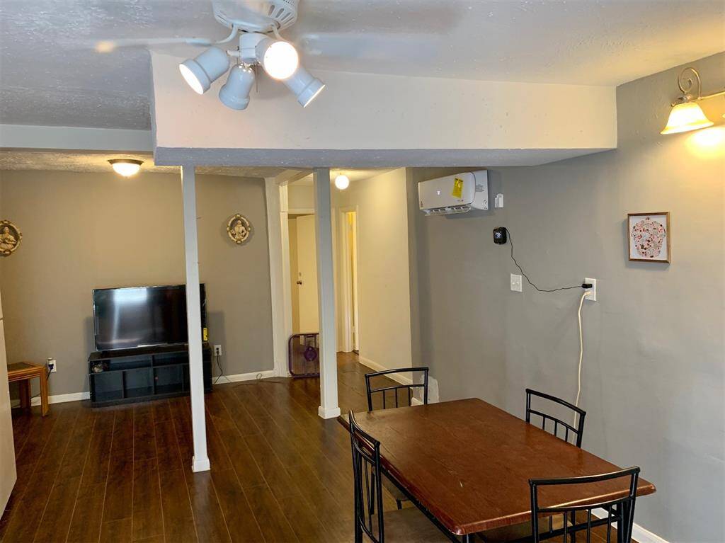 Elegant Dining Space: This room features a classic wooden dining table set, perfect for intimate meals and gatherings, complemented by warm hardwood flooring and modern lighting that creates a cozy and inviting atmosphere.