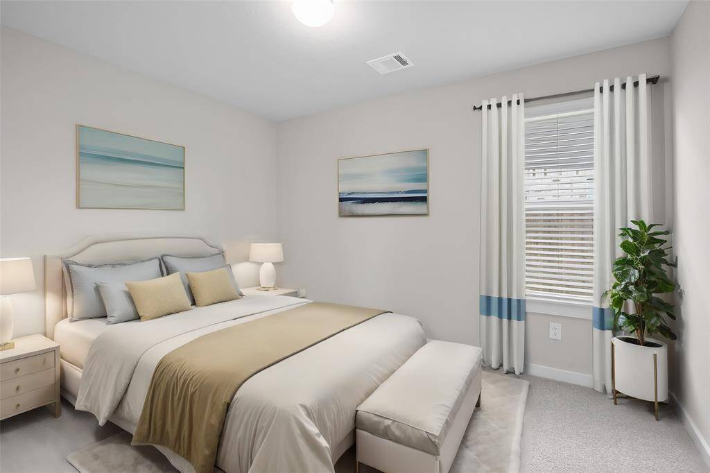 Secondary bedroom features plush carpet, custom paint and a large window with privacy blinds.