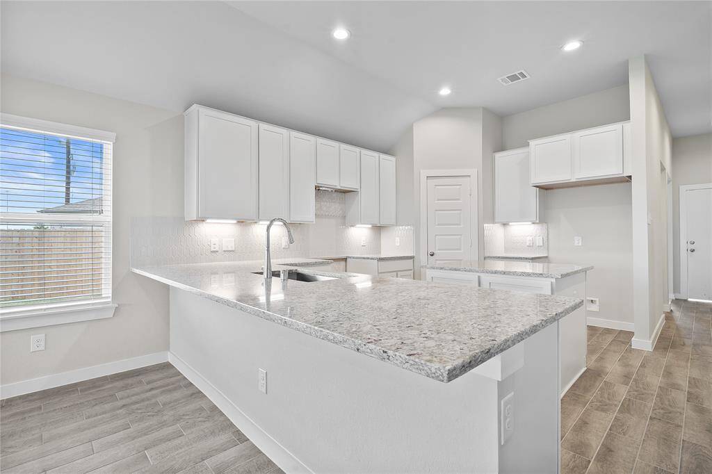 This kitchen is by far any chef’s dream! This spacious kitchen features high ceilings, white stained wood cabinets, granite countertops, SS appliances, modern tile backsplash, recessed lighting, extended counter space, granite kitchen island with space for breakfast bar, and a walk-in pantry all overlooking your huge family room.