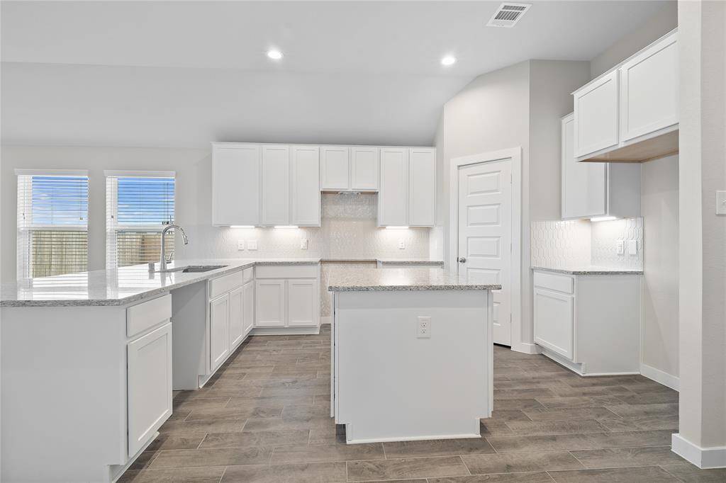 his kitchen is by far any chef’s dream! This spacious kitchen features high ceilings, white stained wood cabinets, granite countertops, SS appliances, modern tile backsplash, recessed lighting, extended counter space, granite kitchen island with space for breakfast bar, and a walk-in pantry all overlooking your huge family room.