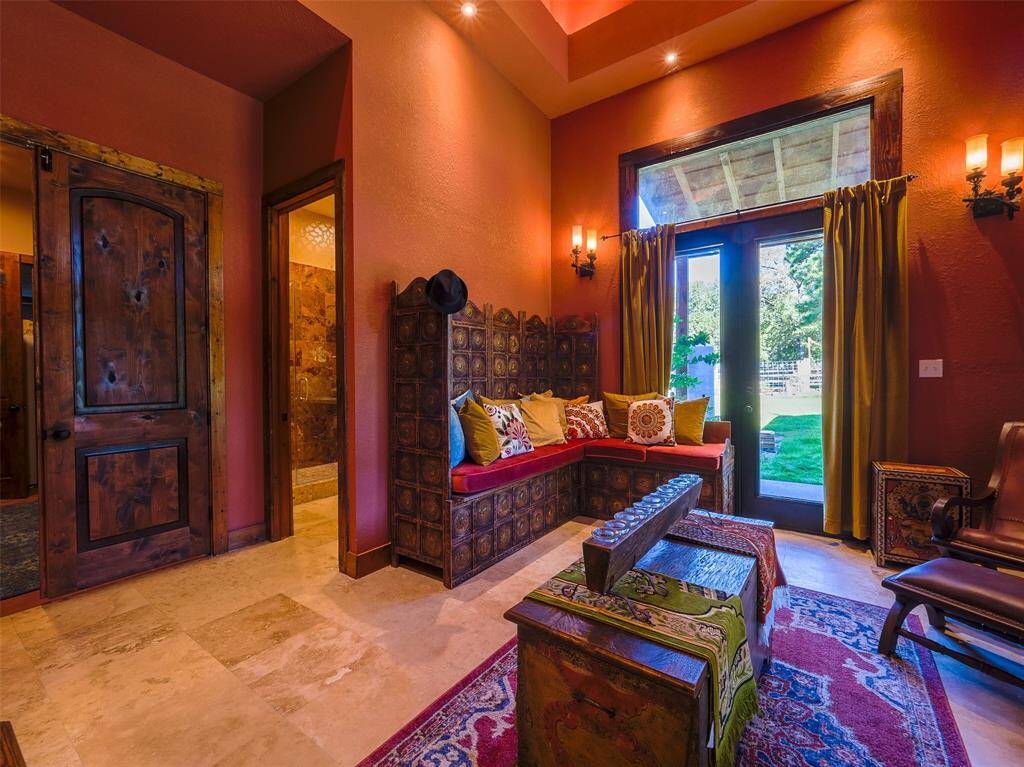 Sitting room in the downstairs primary suite. Travertine floors.  Door out to private patio.
