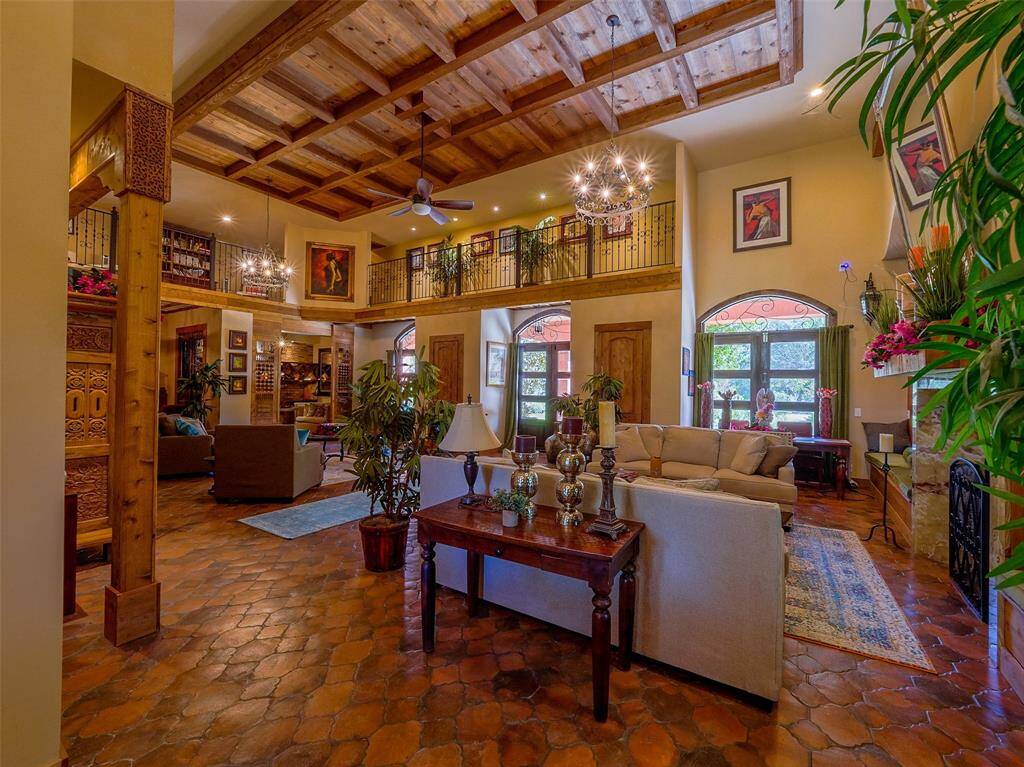 Great room with unique wood ceiling and terracotta tile floor. Gallery overlooks the room from the second floor.