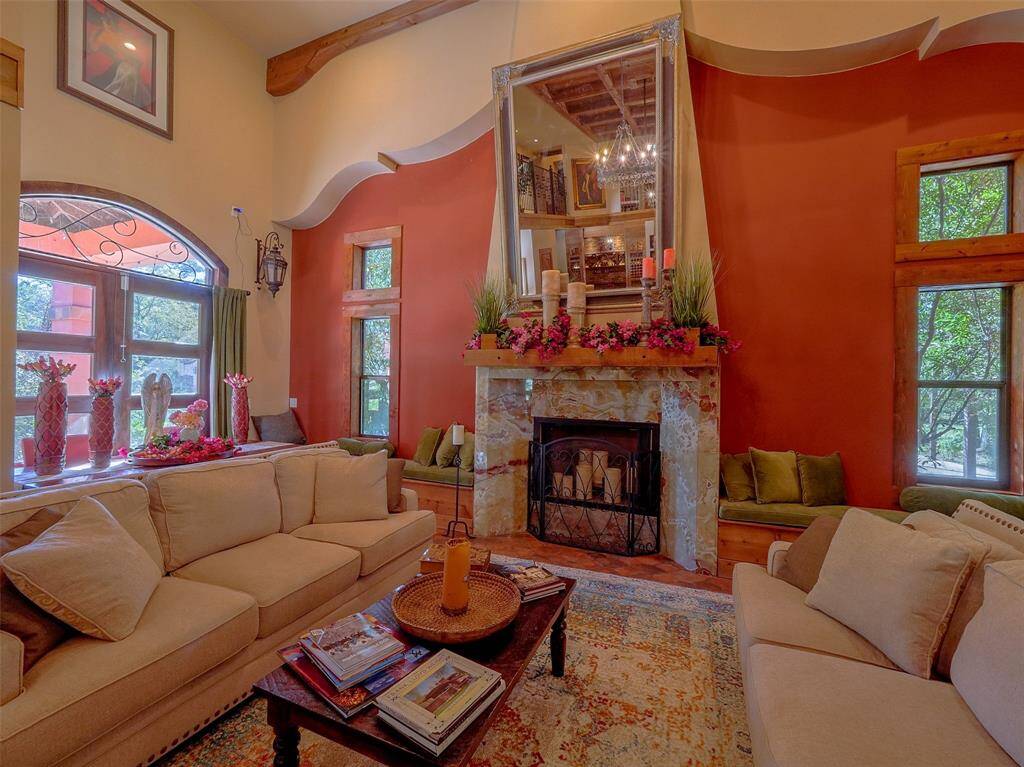 Wood burning fireplace with onyx surround flanked by window seats.