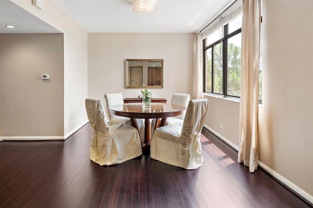 Entertain guests in style in the formal dining area with hardwood floors and bathed in abundant natural light streaming through wide sliding windows.