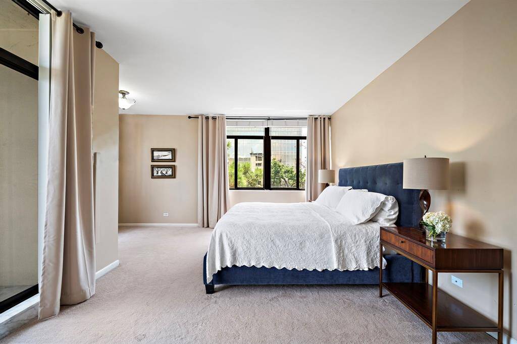 Comfort abounds in the primary suite showcasing carpeted floors, wide sliding windows for abundant natural light, and a private balcony.