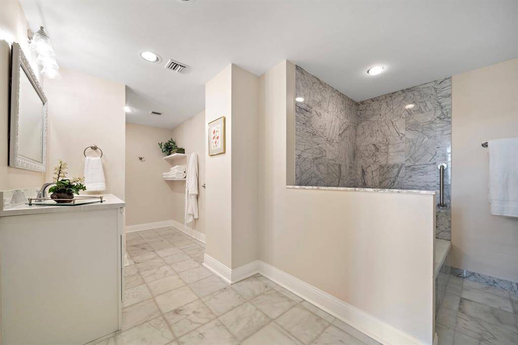 Measured at 17' x 11', this generously sized primary bath comes complete with a glass-enclosed shower and a separate soaking tub.