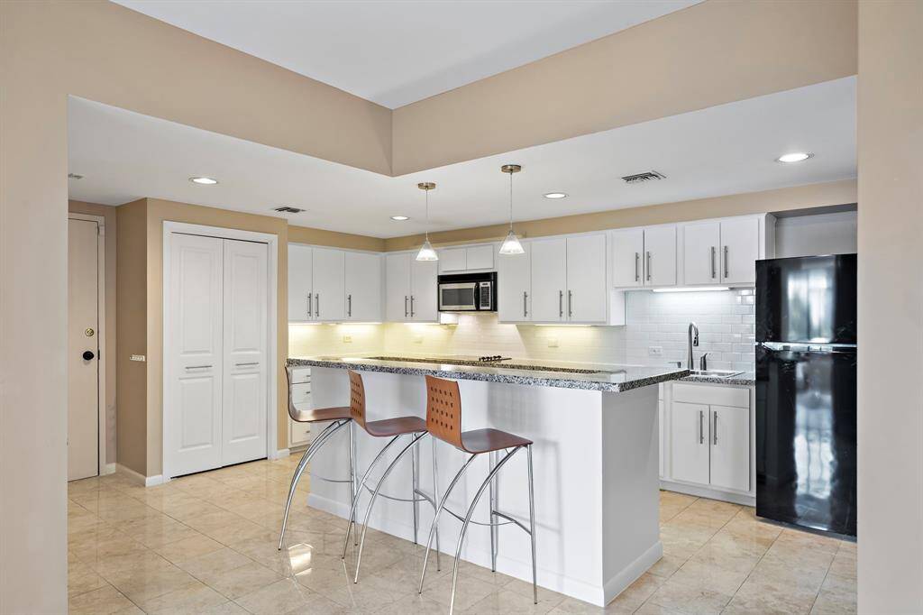 Showcasing the ideal blend of form and function, the spacious kitchen features generous storage space, pantry, granite countertops, and a sizable island complete with a raised bar for additional seating. Designed for convenience, enjoy seamless access to the living and dining areas.