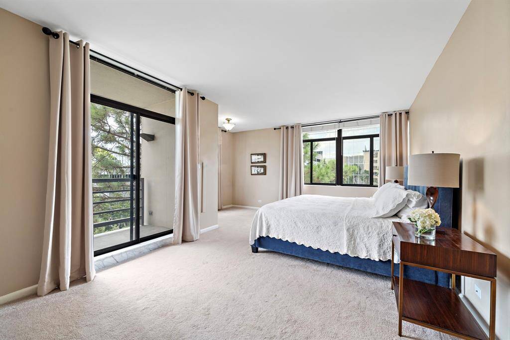 This expansive 23' x 16' primary suite features two spacious walk-in closets, an ensuite bath, ample windows allowing natural light, and lush carpeting throughout. Unwind and enjoy your personal downtime in this sunlit retreat boasting its own balcony.