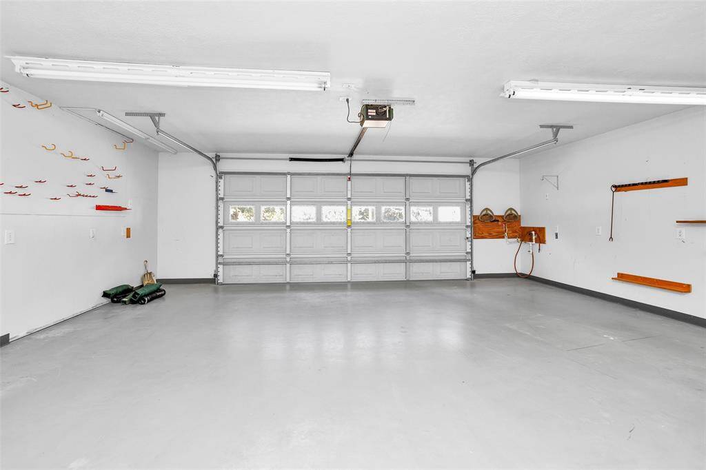 This spacious 23x23 garage features ample storage, built-in shelves, and a convenient pegboard for organizing tools.