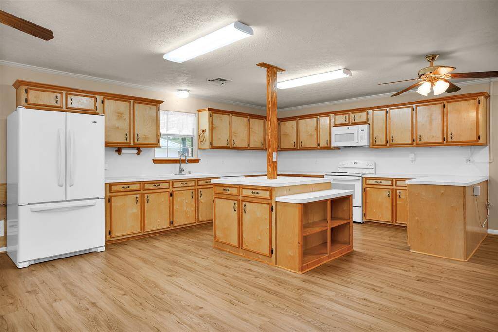 Expansive countertops provide ample space for appliances and meal prep, with convenient side shelves perfect for storing your favorite cookbooks.