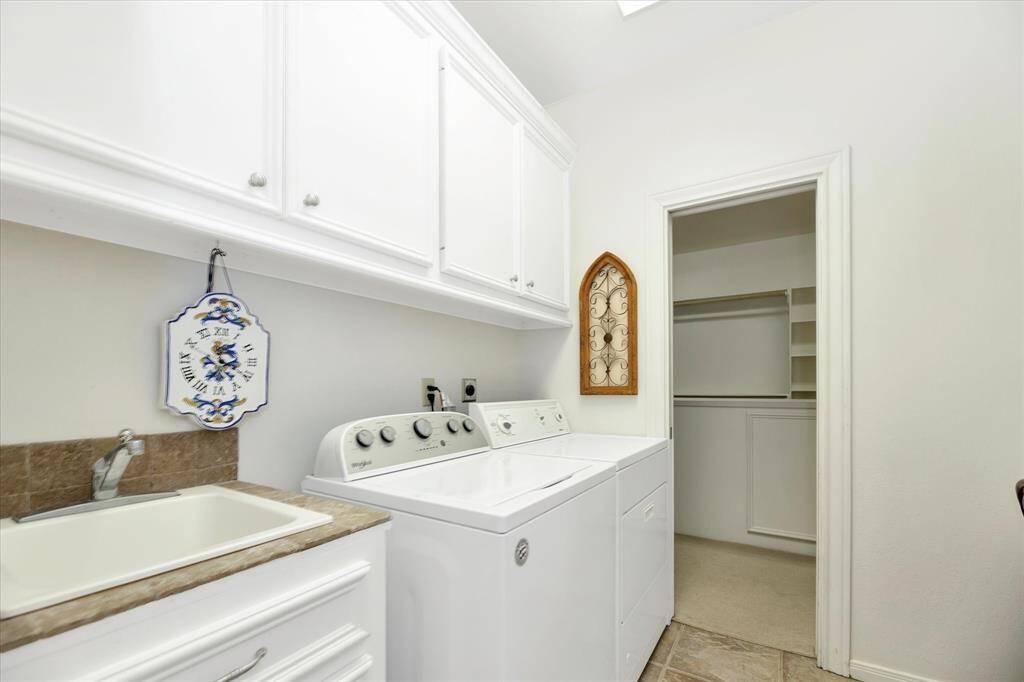 Laundry room has large sink and opens to the primary walk-in closet for convenience.