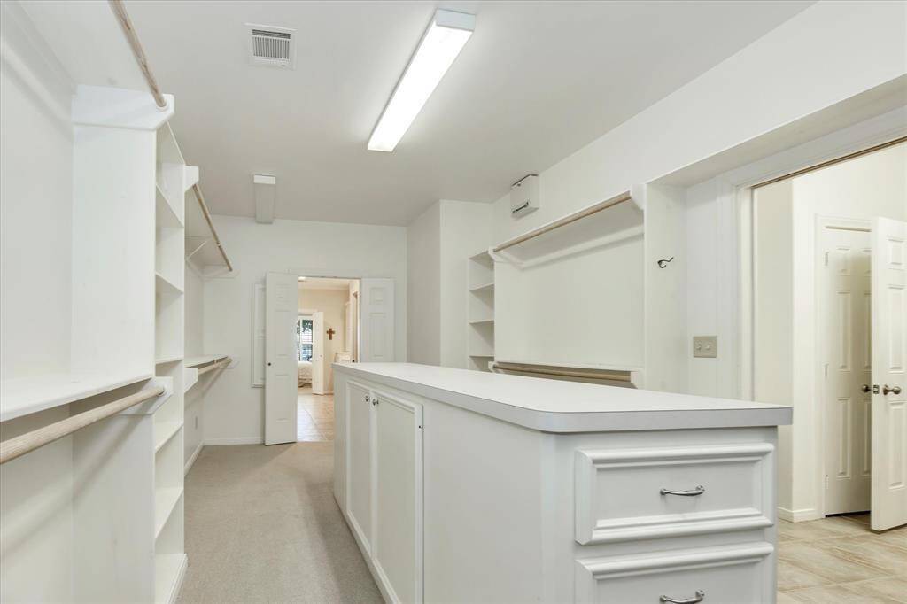20x10 walk-in closet with large island and built-ins.  It opens directly to the laundry room for additional convenience.  This is the ultra organizers dream closet.