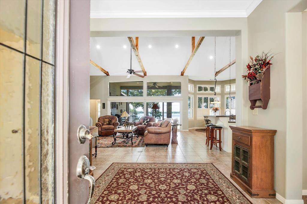 Upon entering the home you are greeted by high beamed ceilings and gorgeous lakeside views.