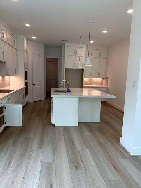 Kitchen showcases upper cabinets and large island for additional seating or cooking.