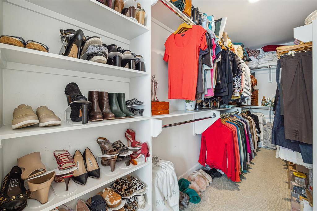 Ample walk-in closet with shoe shelving and built-ins, neutral carpet and Lutron lighting turns on/off automatically upon entry and exit.