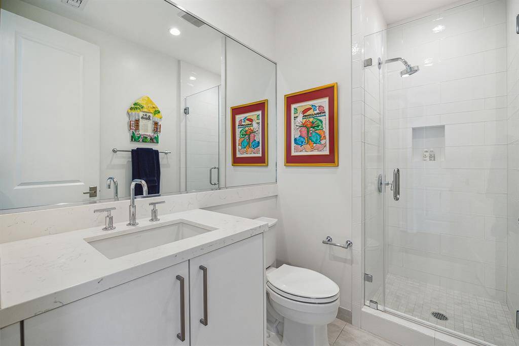 2nd full bath features  seamless glass shower with neutral tiles, gleaming porcelain floors and countertops. Lutron lights turn on/off automatically upon entry and exit.