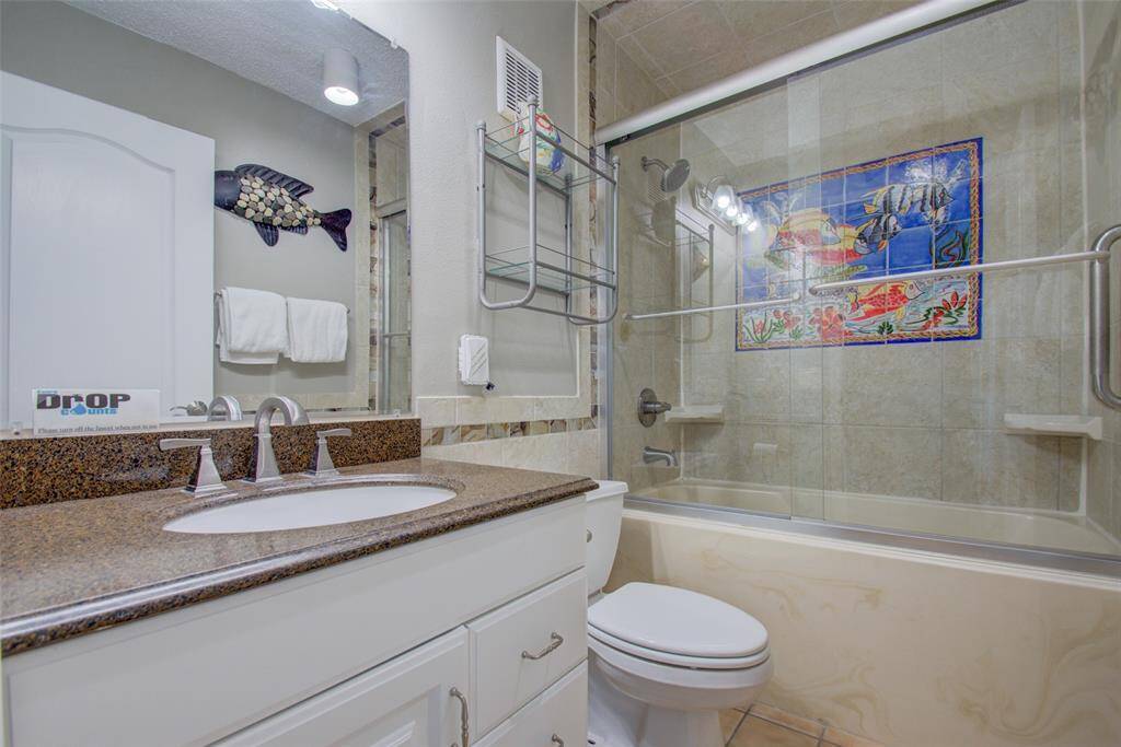 The second bathroom features sleek and stylish tiles, and soft lighting, creating a relaxing and indulgent spa-like atmosphere.