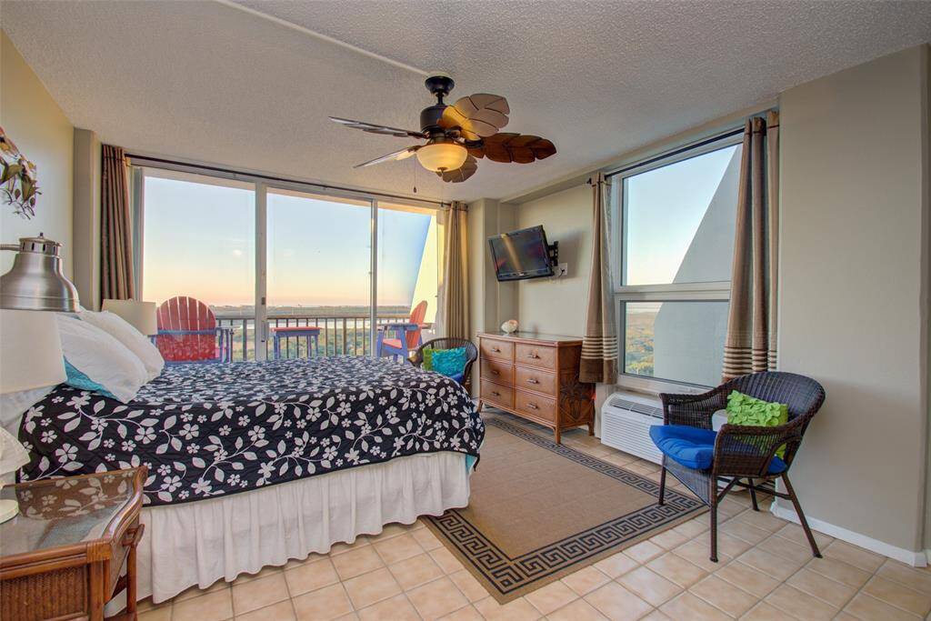 The primary bedroom features large windows with a beautiful view, and walk out patio.