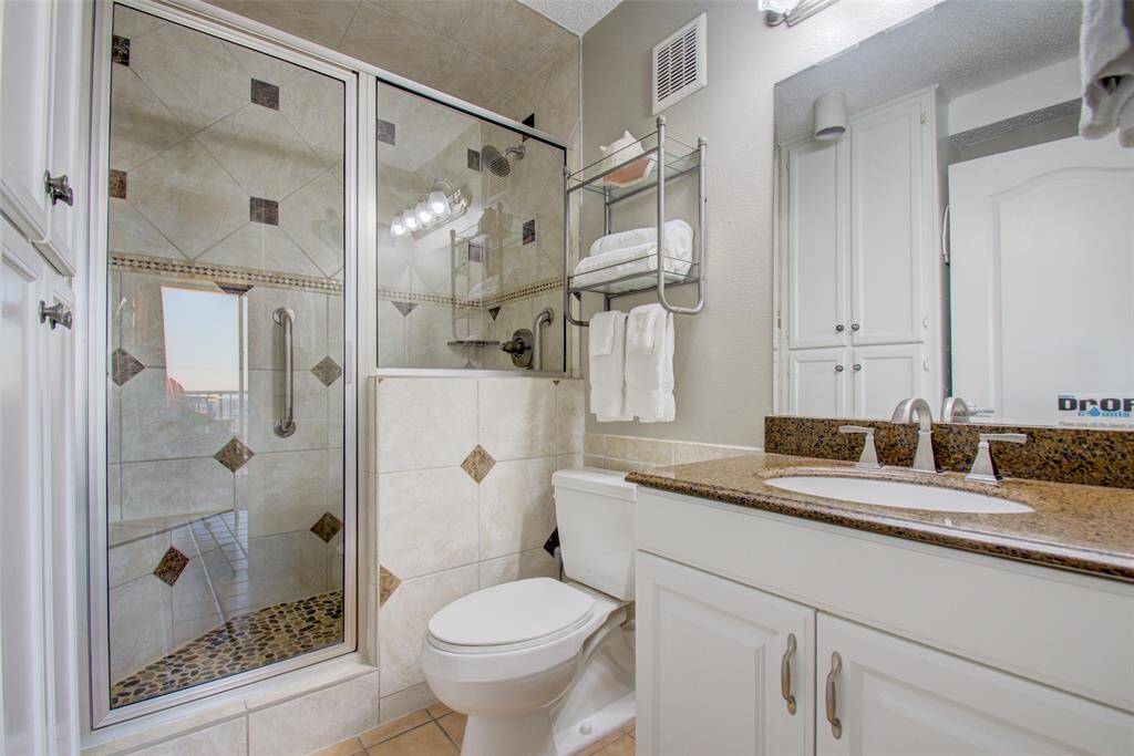 A spa-like beautiful bathroom with modern fixtures, including a glass-enclosed shower, and a double vanity.