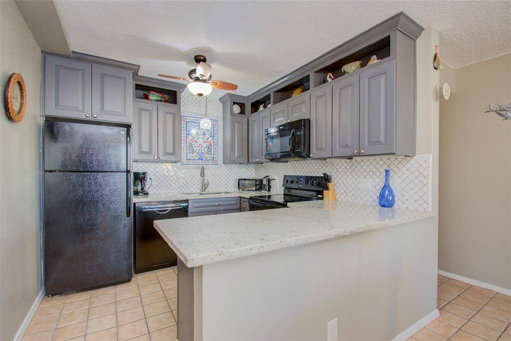 The kitchen is equipped with a large refrigerator, an oven, a stove, microwave, and dishwasher, making it perfect for those who love to cook and entertain.