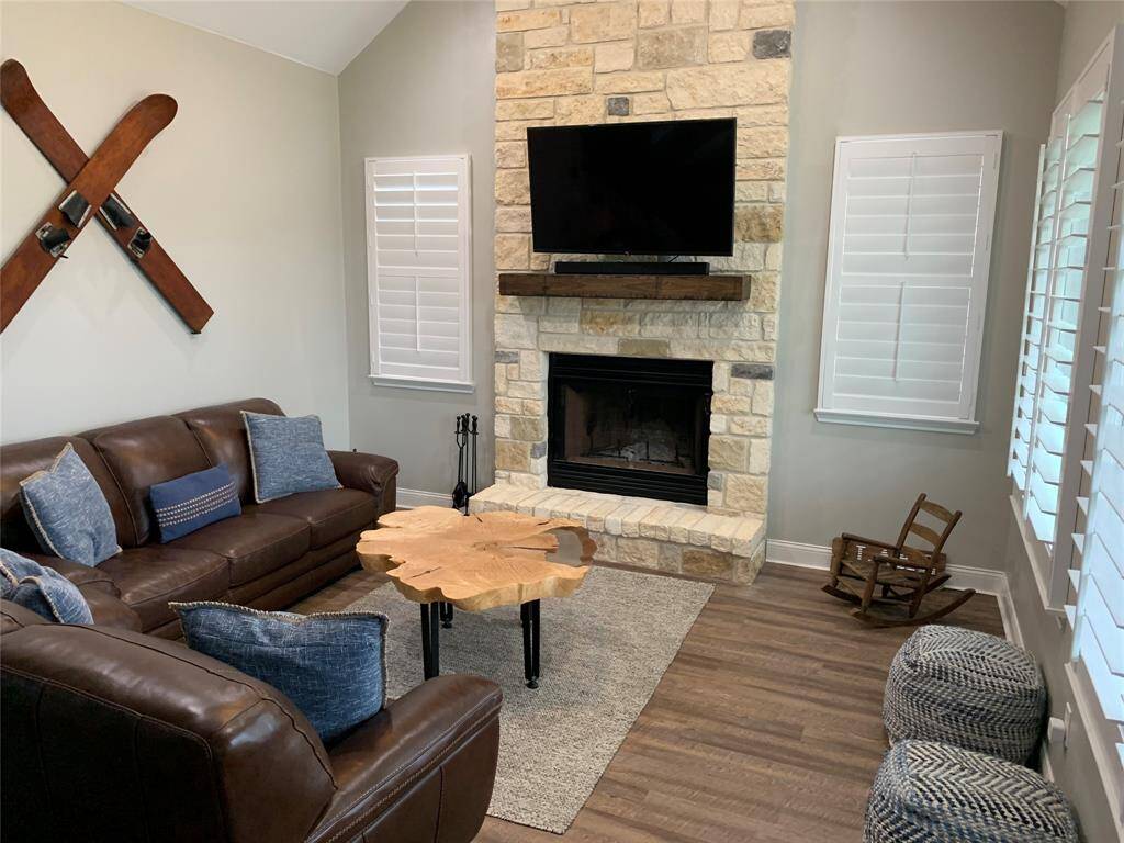 Living room with wood burning fireplace and window views of the lake down the street