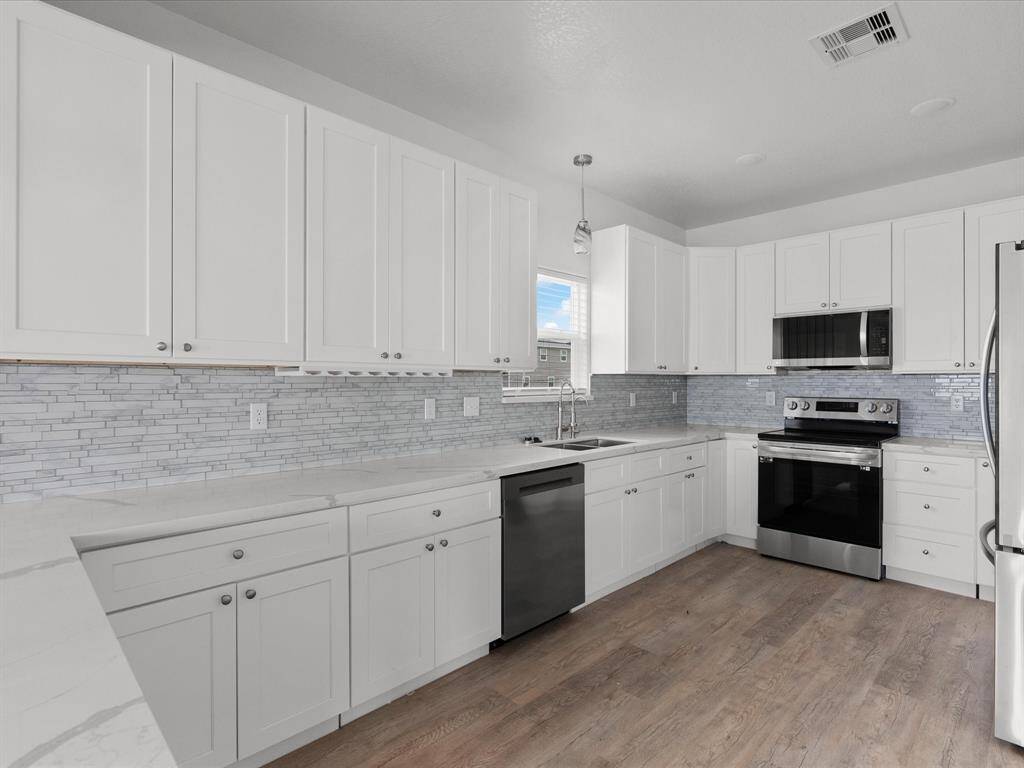 Sleek, modern kitchen with elegant cabinetry, stainless steel appliances, and a stylish backsplash—perfect for culinary enthusiasts.