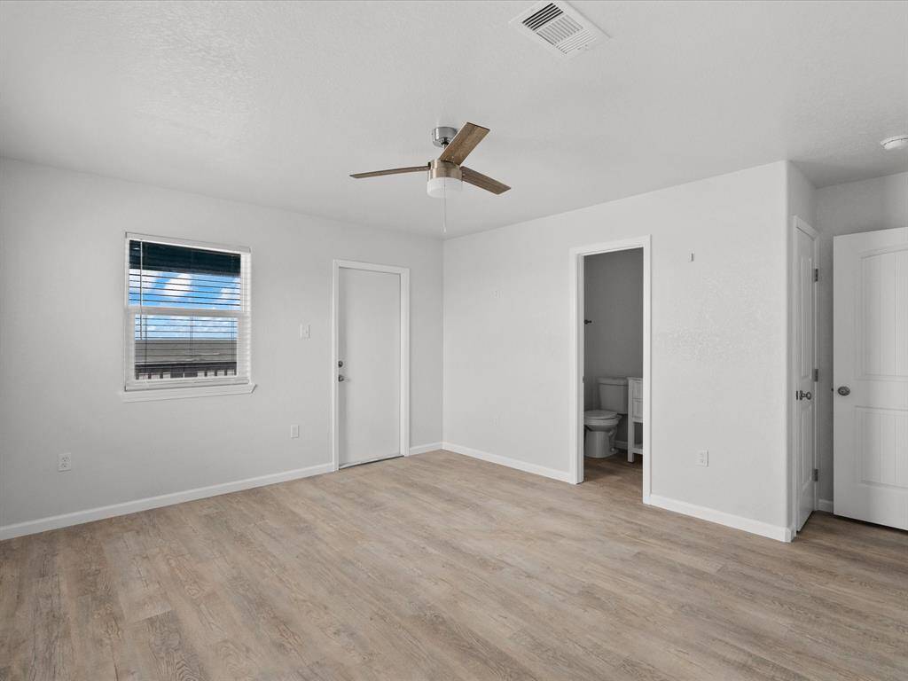 This bedroom, located just off the stairs, features a private bathroom with a shower and direct access to the upstairs deck.