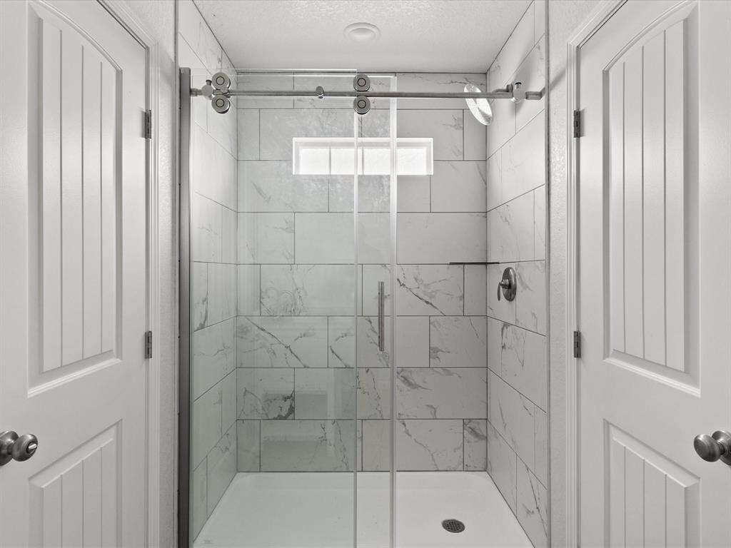 Elegant master bathroom featuring a luxurious tiled walk-in shower.