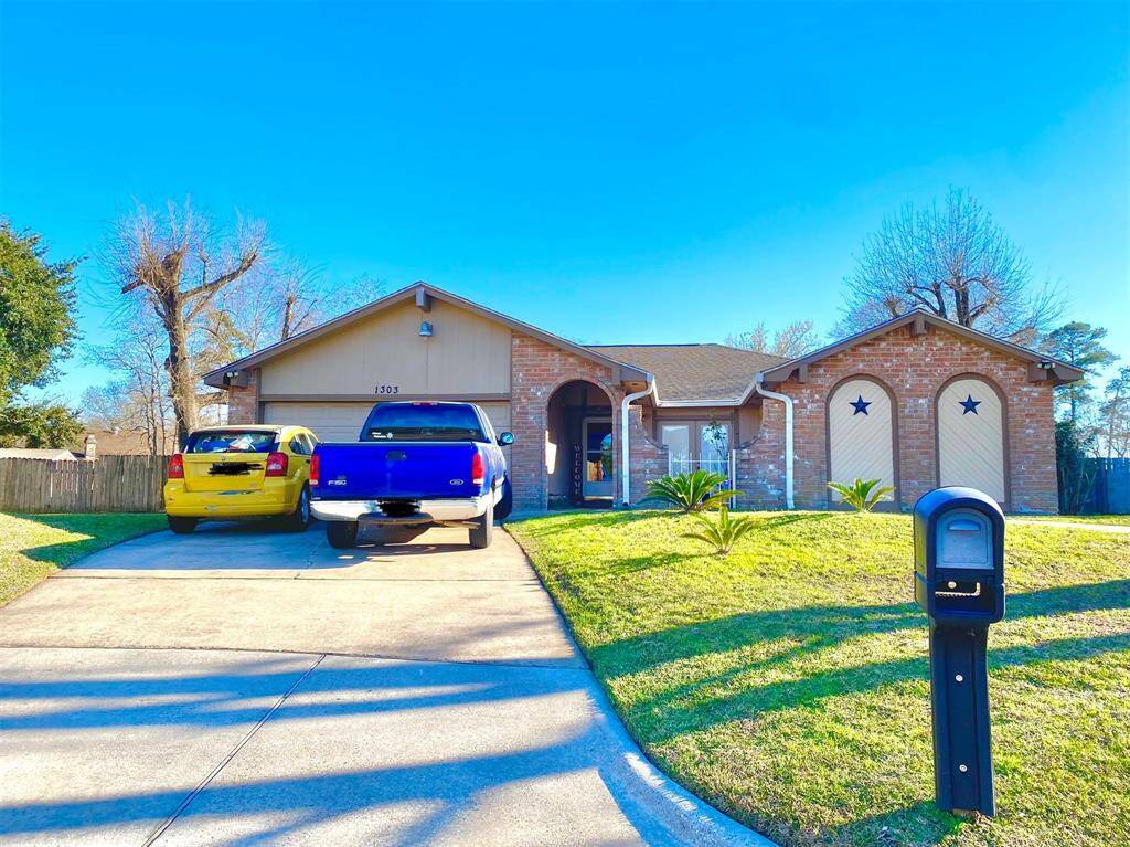 This charming single-story brick home features a two-car garage with decorative star accents, a neatly maintained front yard, and a spacious driveway. The property offers a welcoming curb appeal in a suburban setting.
