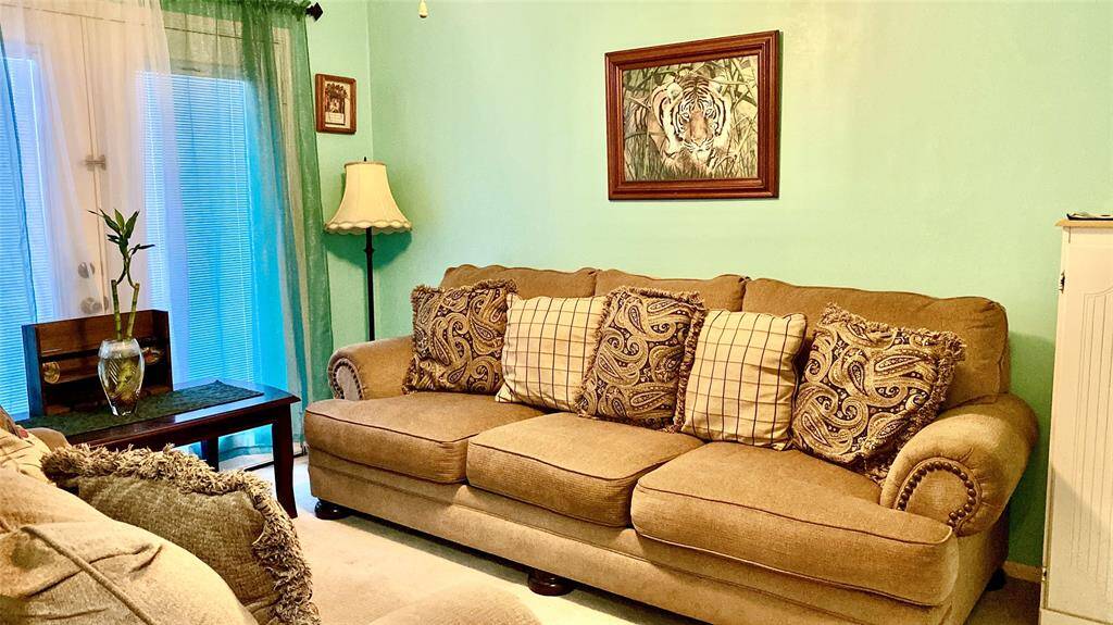 This bedroom is being used as separate meeting room. The walls are painted a soft green, complemented by a framed artwork.