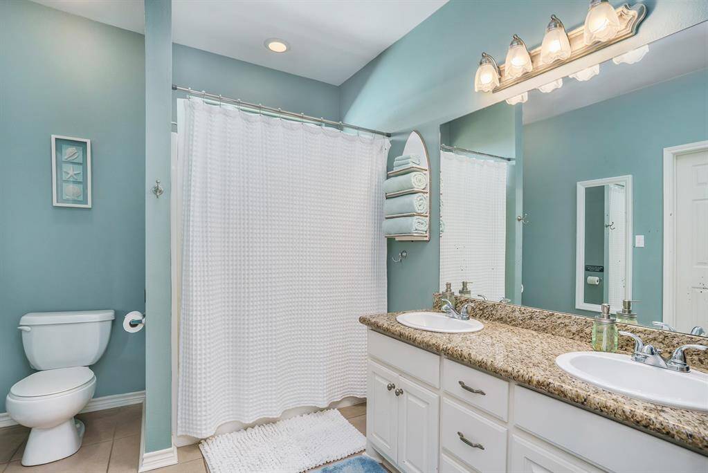 Primary bathroom with a shower/tub combo and double sinks.