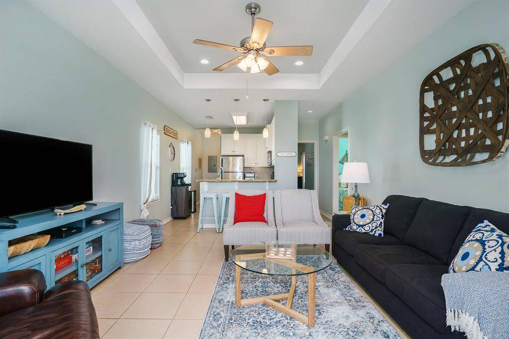 Spacious living area with recessed lighting and a tray ceiling, open to the kitchen area.