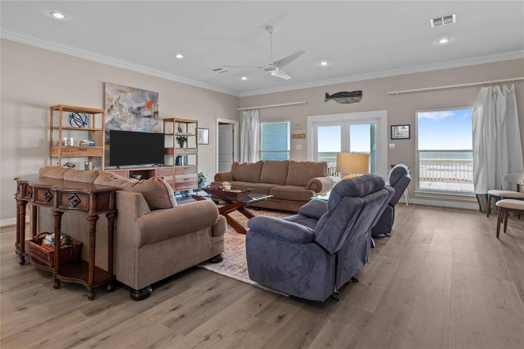 Coastal deck with several great heavy duty bar height chairs overlooking the ocean, under a clear sky, with a comfortable seating area to the side.