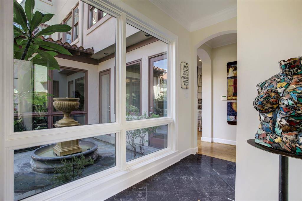 Step into the entry where you are greeted with a light washed space with a view of a water feature tucked neatly into the patio space.