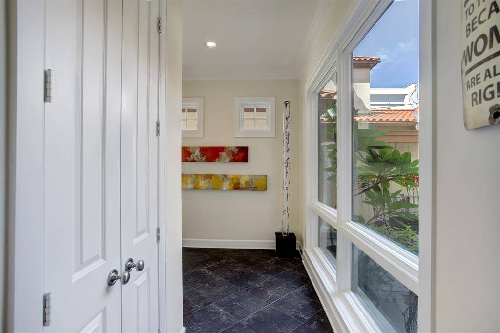 This is the view over your shoulder as you pass into the kitchen area and again see the lush outdoors through the ceiling to floor windows in the entry.