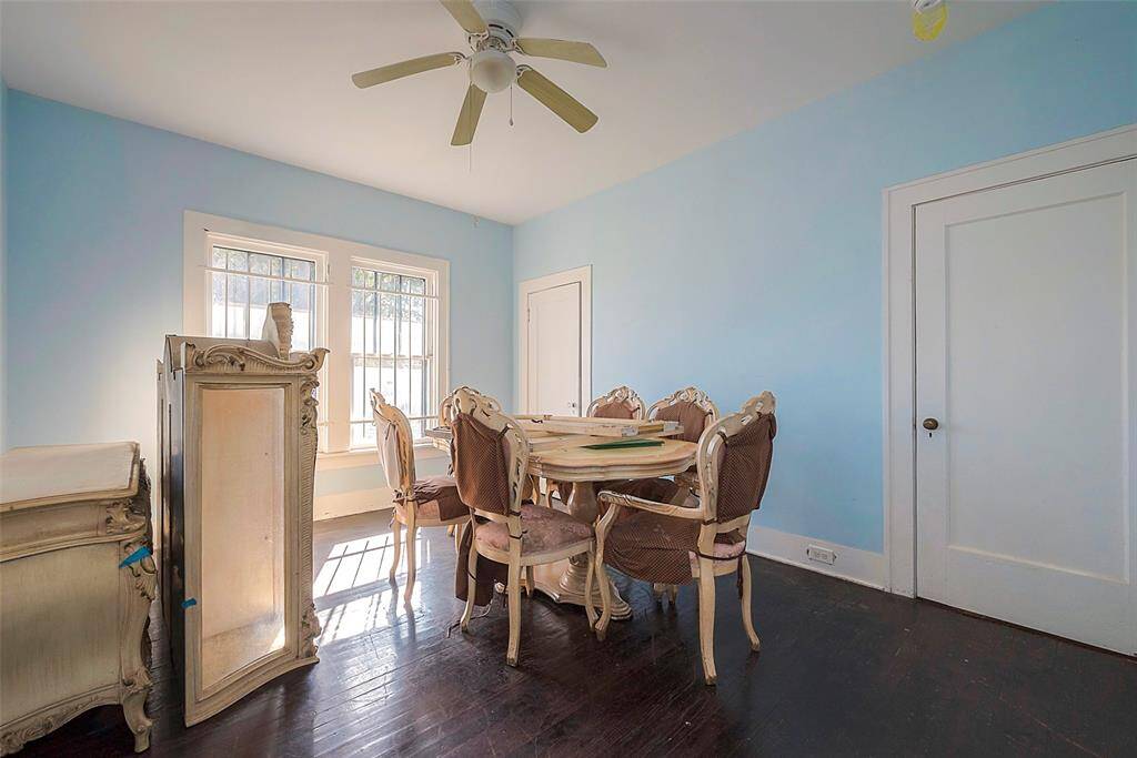 Dining room with wooden table and chairs, set for four people, elegant decor, natural light filtering in through window.