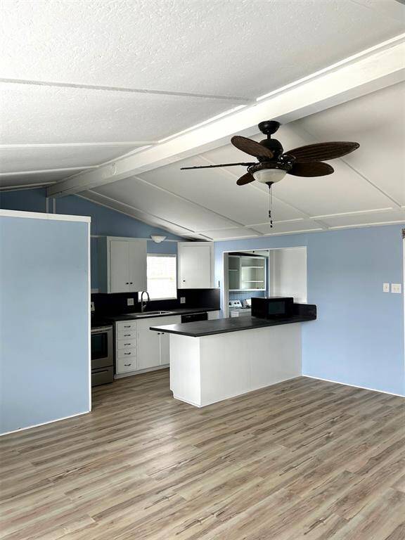 Open kitchen with pull-up bar seating and utility room with appliances