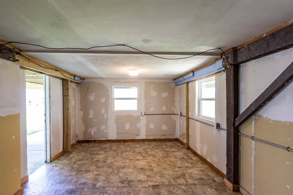 Versatile ground-level space with AC, storm windows, and electric shutters. Abundant electrical outlets make it ideal for an office, storage, entertainment, or extra sleeping quarters.