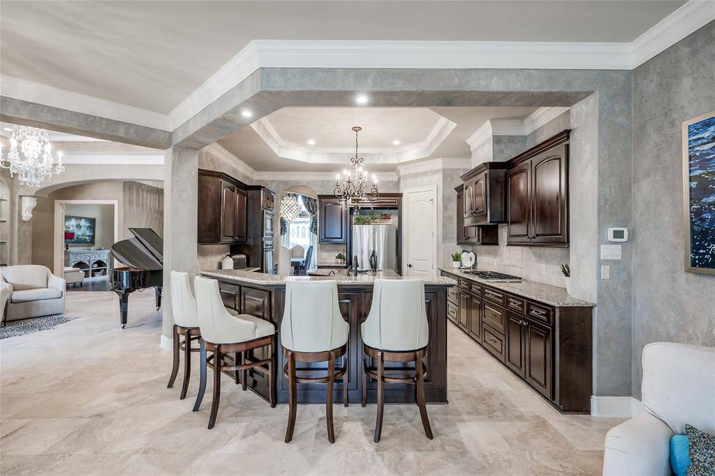 A fully equipped chef’s kitchen is designed with luxury and function. Open to the family room and adjacent breakfast area.