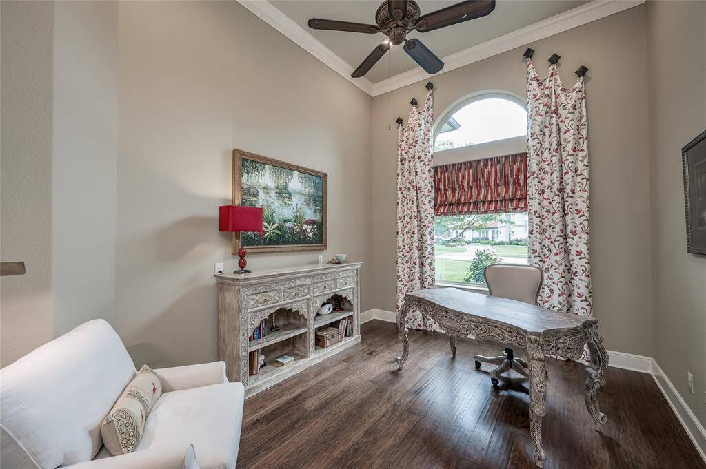 A private study with grand ceilings and rich wood flooring.