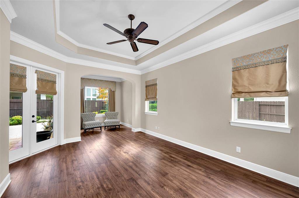 The luxurious owner’s suite offers beautiful 14 ft tray ceilings with a picturesque window in the sitting area alcove. A glass panel door allows private access to the lushly designed backyard.