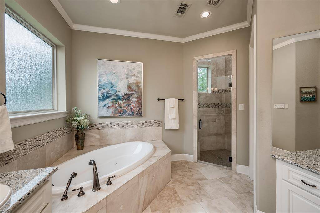 Escape to a large walk-in steam shower with natural travertine stone surround.